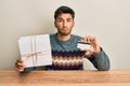 Young handsome man holding gift and credit card depressed and worry for distress, crying angry and afraid Royalty Free Stock Photo