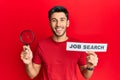 Young handsome man holding magnifying glass for job search smiling and laughing hard out loud because funny crazy joke Royalty Free Stock Photo
