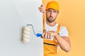 Young handsome man holding roller painter over white banner depressed and worry for distress, crying angry and afraid Royalty Free Stock Photo