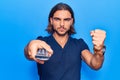 Young handsome man holding television remote control annoyed and frustrated shouting with anger, yelling crazy with anger and hand Royalty Free Stock Photo