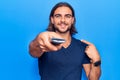 Young handsome man holding television remote control pointing finger to one self smiling happy and proud Royalty Free Stock Photo
