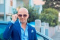 Young handsome man holding touching sunglasses posing near his car Royalty Free Stock Photo