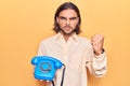 Young handsome man holding vintage telephone annoyed and frustrated shouting with anger, yelling crazy with anger and hand raised Royalty Free Stock Photo