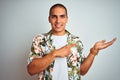 Young handsome man on holidays wearing Hawaiian shirt over white background amazed and smiling to the camera while presenting with Royalty Free Stock Photo