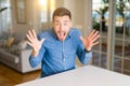 Young handsome man at home very happy and excited, winner expression celebrating victory screaming with big smile and raised hands Royalty Free Stock Photo