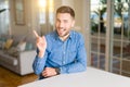 Young handsome man at home very happy pointing with hand and finger to the side Royalty Free Stock Photo