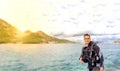 Young handsome man isolated diver smiling ready to go scuba diving in cold water wet suit, fins, weight belt & oxigen Royalty Free Stock Photo