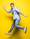 Young handsome man jumping on yellow background. Jump, freedom, summer. Royalty Free Stock Photo