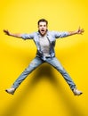 Young handsome man jumping on yellow background. Jump, freedom, summer.