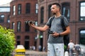 Young handsome man launching drone quadcopter at urban background