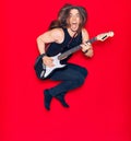 Young handsome man with long hair and aggressive expression playing electric guitar Royalty Free Stock Photo