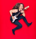 Young handsome man with long hair and aggressive expression playing electric guitar Royalty Free Stock Photo