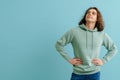 Young handsome man with long hair in hoodie looking upward