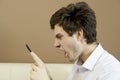 Man looks angrily at the smartphone.