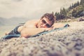 Young handsome man is lying on the beach, sun glasses