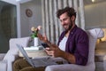 Young handsome man making video call with friends while sitting on sofa at his modern home.Concept of happy business people. Royalty Free Stock Photo