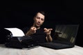 Man midway between a typewriter and laptop on black background in low key.The concept of the past and the future Royalty Free Stock Photo