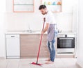 Man mopping floor in kitchen