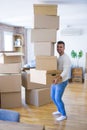 Young handsome man moving to a new apartment, holding a pile of cardboard boxes, happy for new home Royalty Free Stock Photo