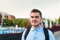 Young handsome man with mustache is standing near apartments complex