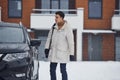 Young handsome man outdoors near his modern black car at winter time Royalty Free Stock Photo