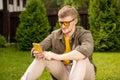 Young handsome man outdoors texting message in dating service on smartphone