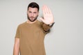 Young handsome man over isolated background with open hand doing stop sign with serious and confident expression, defense gesture Royalty Free Stock Photo