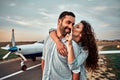 Young handsome man pilot is standing near small private plane with his beautiful young woman Royalty Free Stock Photo