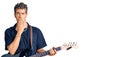 Young handsome man playing electric guitar covering mouth with hand, shocked and afraid for mistake Royalty Free Stock Photo