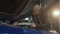 Young handsome man repairing his car at the garage Royalty Free Stock Photo