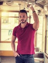 Young handsome man riding on tram or old bus in city