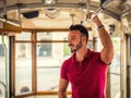 Young handsome man riding on tram or old bus in city