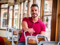Young handsome man riding on tram or old bus in city