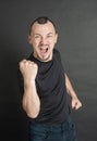 Young handsome man screaming with fist up protest gesture