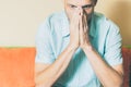 Young handsome man in the shirt cover his face with his hands feeling depressed and miserable while hi thinking about life. Royalty Free Stock Photo