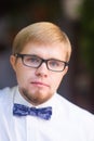 Portrait of young handsome man with short hair wearing a bow tie and posing in the city streets. Royalty Free Stock Photo