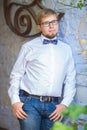 Young handsome man with short hair wearing a bow tie and posing in the city streets. Royalty Free Stock Photo