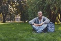 Young handsome man sitting on grass outdoors Royalty Free Stock Photo
