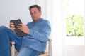 Young handsome man sitting in home using tablet computer Royalty Free Stock Photo