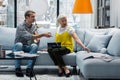 Young handsome man sitting at new sofa with elderly mother