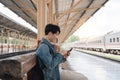 Young handsome man sitting and using smartphone at train station Royalty Free Stock Photo