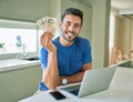 Young handsome man smiling happy holding england pounds banknotes at home