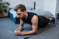 Young handsome man in sportswear doing a planking exercise on floor Royalty Free Stock Photo