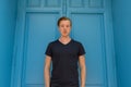 Young handsome man standing in front of blue door Royalty Free Stock Photo