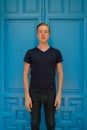 Young handsome man standing in front of blue door Royalty Free Stock Photo