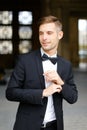 Young handsome man standing and posing, wearing black suit and bow tie. Royalty Free Stock Photo