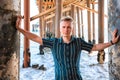 Young handsome man stands under a wooden pier on Malibu beach, California Royalty Free Stock Photo
