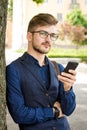 Handsome man in the street with a phone in his hands Royalty Free Stock Photo