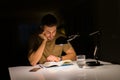 Young handsome man studying at home, reading a book at night Royalty Free Stock Photo