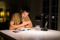 Young handsome man studying at home, reading a book at night Royalty Free Stock Photo